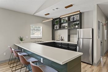 A kitchen with a long island and stainless steel appliances.at Eastlake Gardens, Decatur Georgia