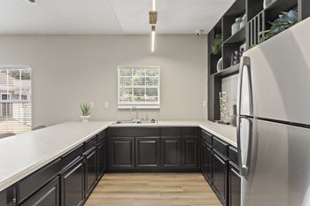 A kitchen with black cabinets and a white refrigerator.at Eastlake Gardens, Georgia