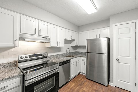 A kitchen with white cabinets and stainless steel appliances.