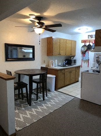 a kitchen with a round table and a ceiling fan