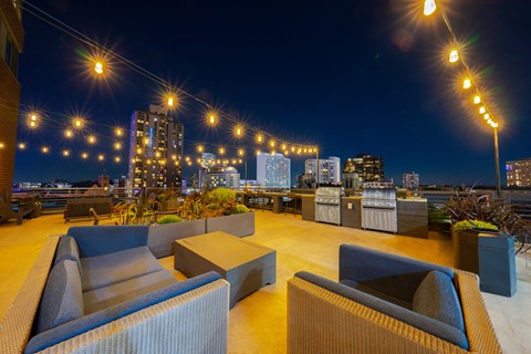 a roof top bar with a view of the city at night at ELEVATE Apartment Homes, Minnesota, 55403
