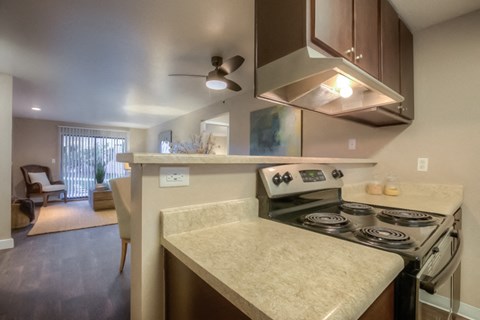 a kitchen with a stove and a ceiling fan