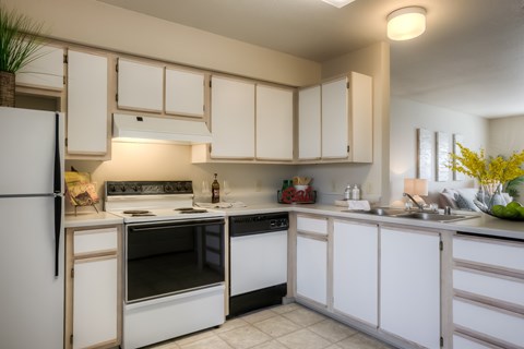 A kitchen with white appliances and cabinets.