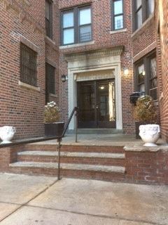 the front door of a brick building with steps