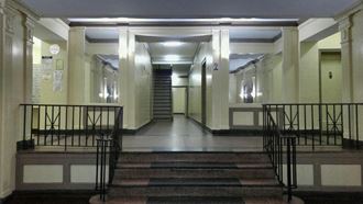 the lobby of a building with stairs and columns