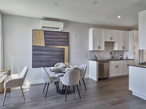 a kitchen and dining room with white cabinets and a table and chairs