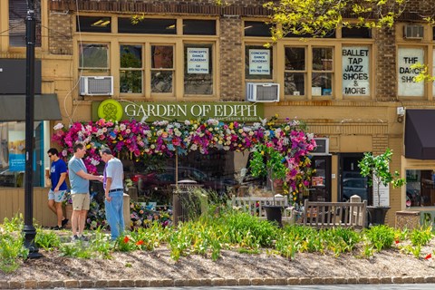 A flower shop called Garden of Edith is located in front of a building.