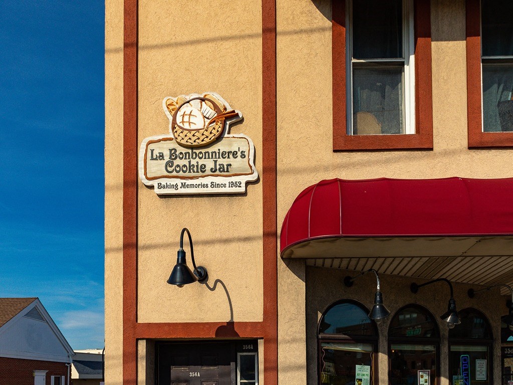 the front of a bakery with a sign and a clock