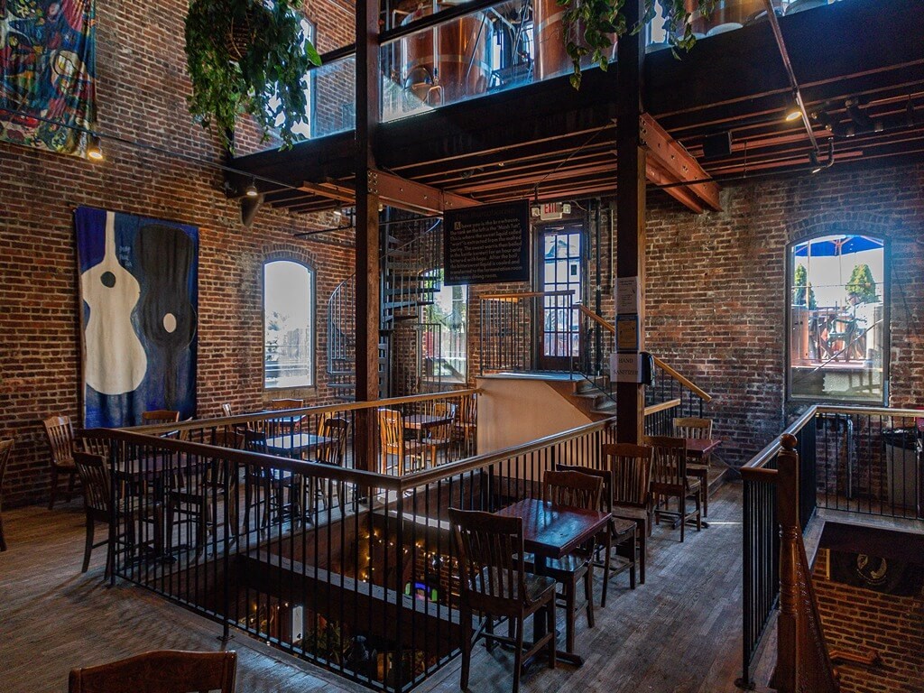 the interior of a restaurant with a bar and tables