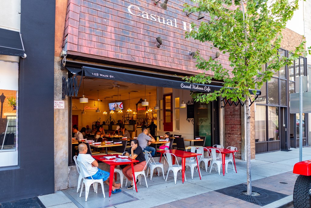 A restaurant named Casual Hut has tables and chairs set up on the sidewalk.