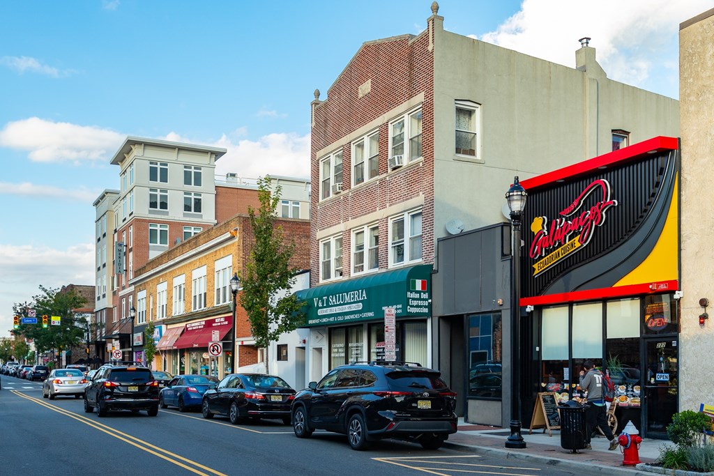 Cars parked on the side of a street in front of a building with a sign that reads