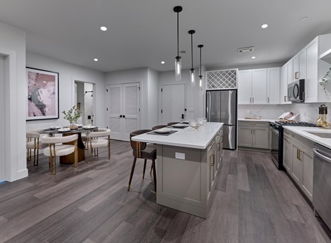 A modern kitchen with a dining table and chairs.