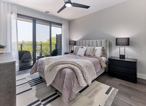 A bedroom with a large bed and a ceiling fan.