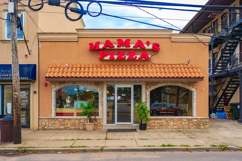 A pizza shop named Mama's Pizza is located on a street corner.
