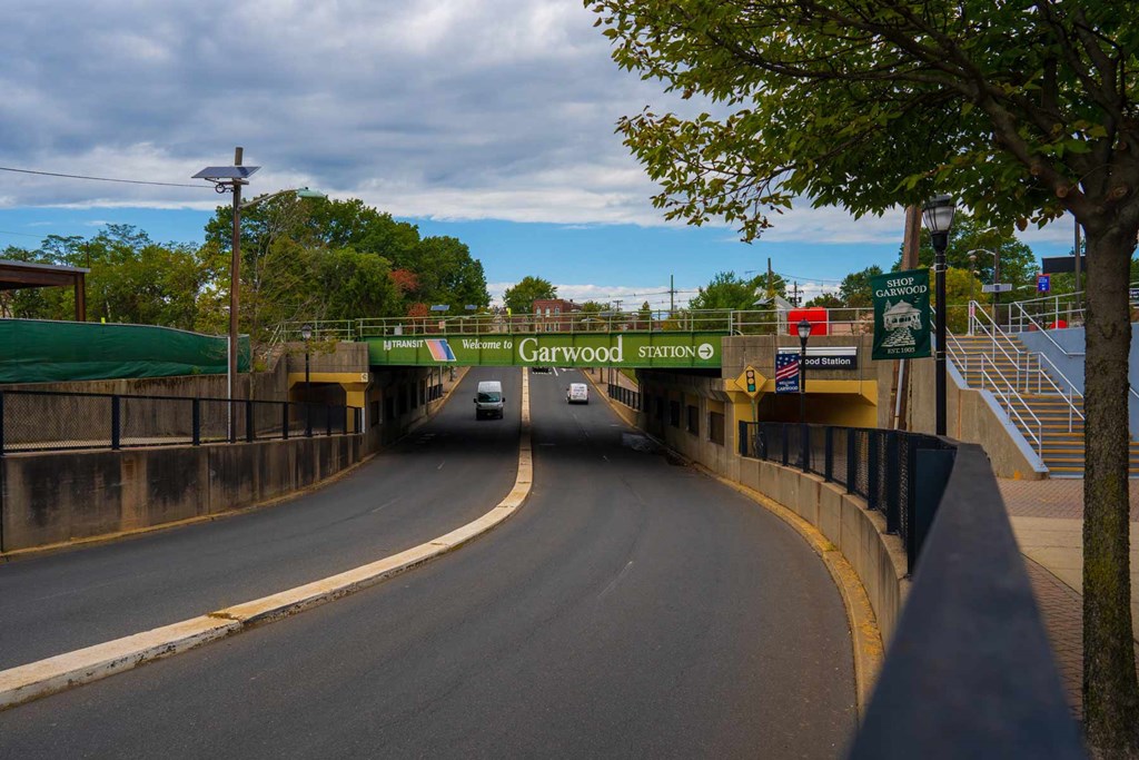 A street view of Garwood Station with a car driving on the road.