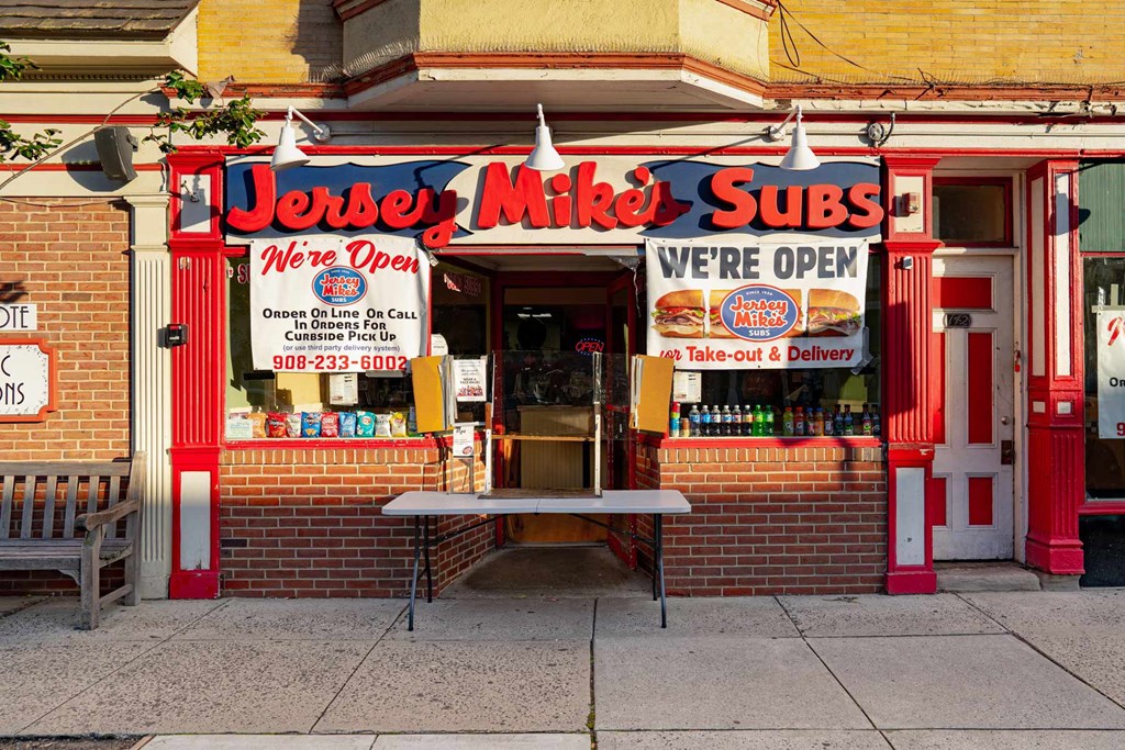 A red and yellow sub shop with a sign that says "Jersey Mike's Subs".