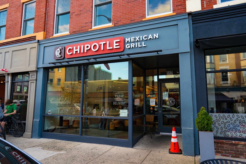 A Chipotle Mexican Grill restaurant with a bicycle parked in front.
