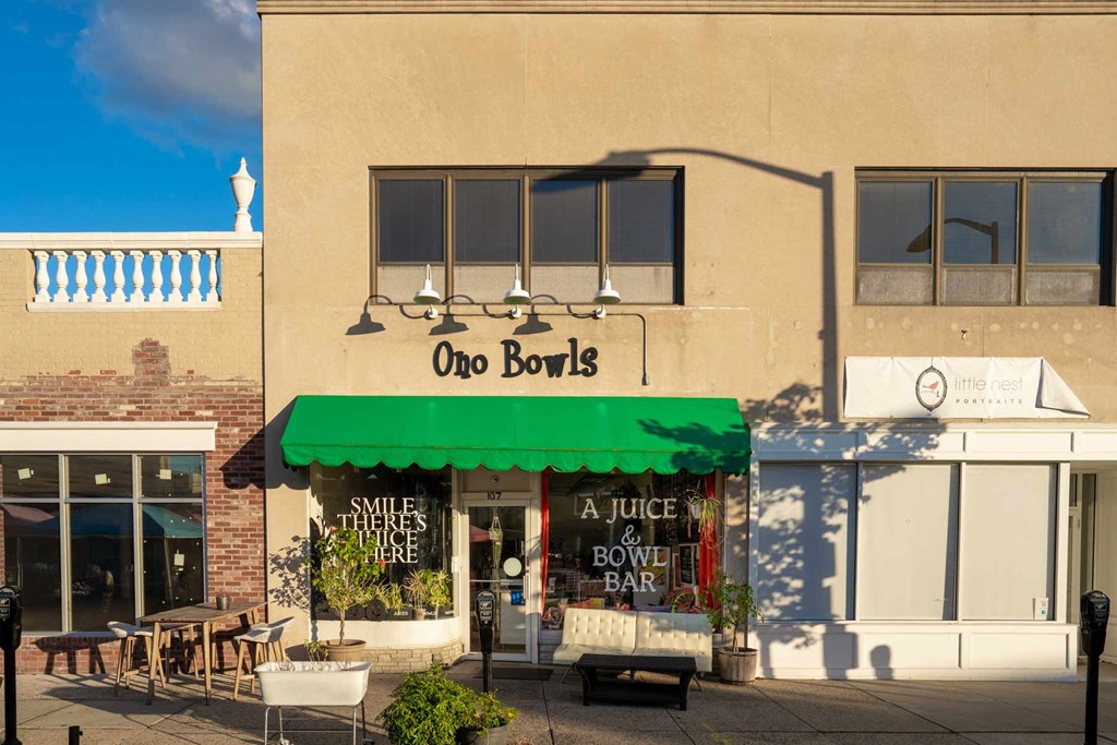 A storefront with a green awning and a sign that reads "Ono Bowls".