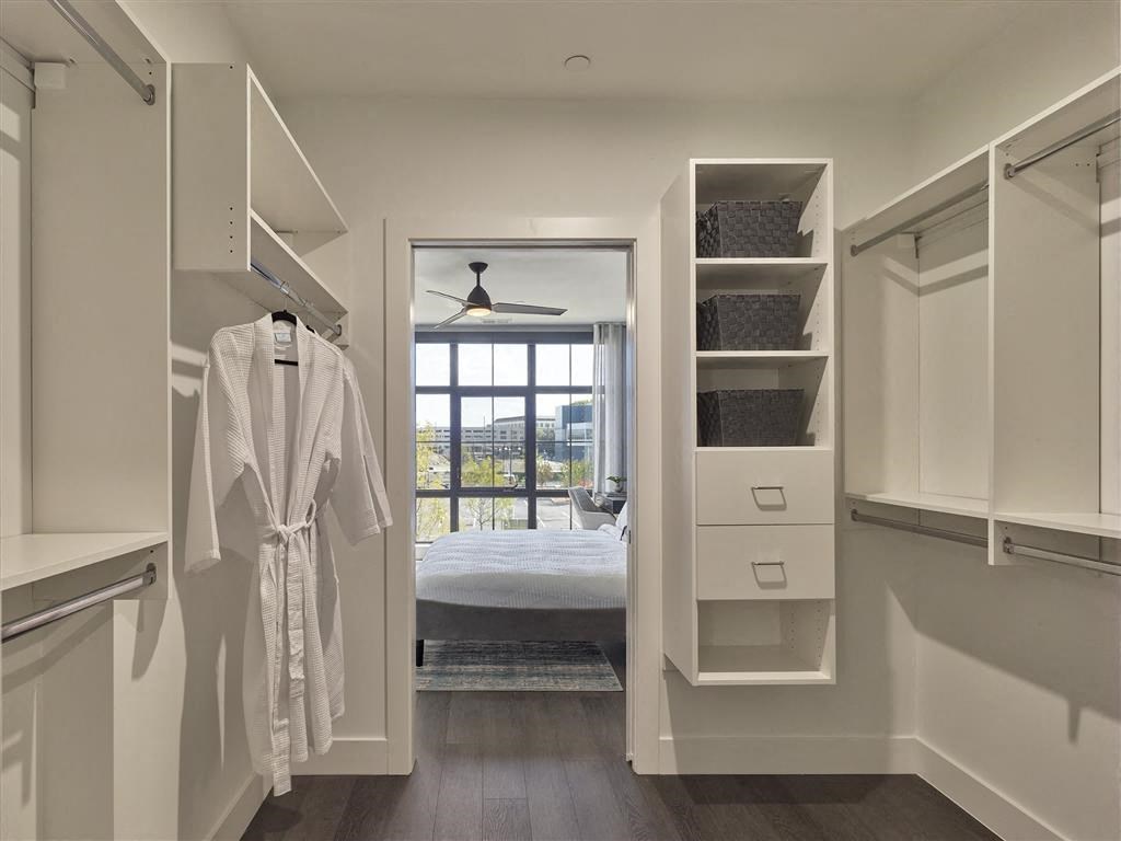A white bathroom with a white robe hanging on the wall.