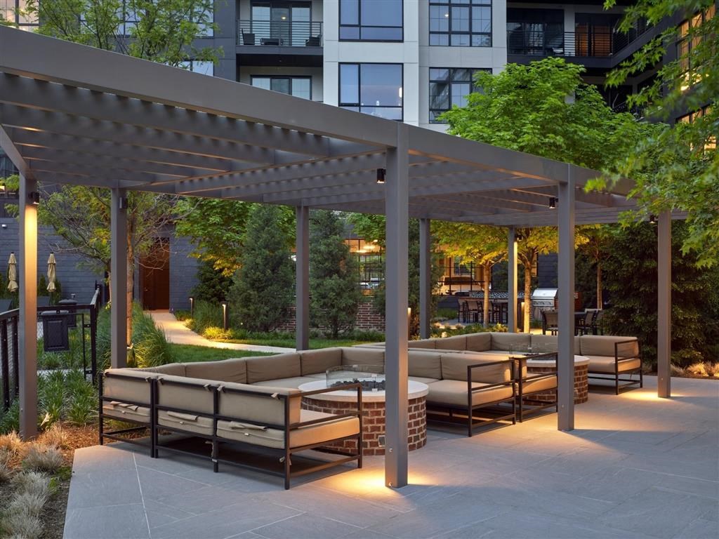 A patio with a pergola and seating area.
