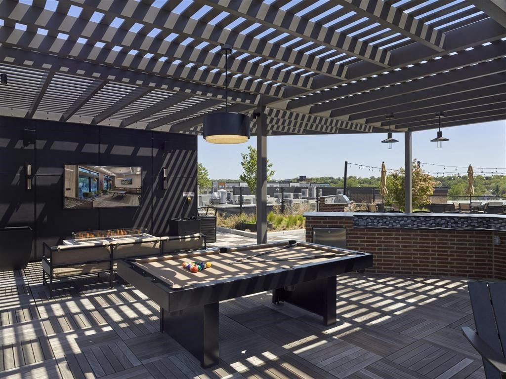 A patio with a table and chairs under a striped awning.