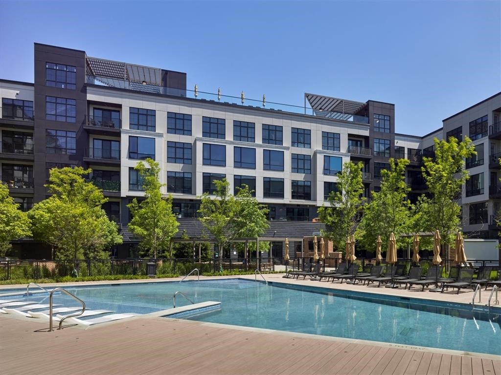 A large building with a pool in front of it.