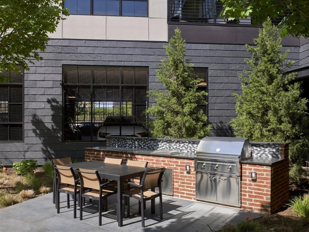 A patio with a table and chairs is in front of a building.