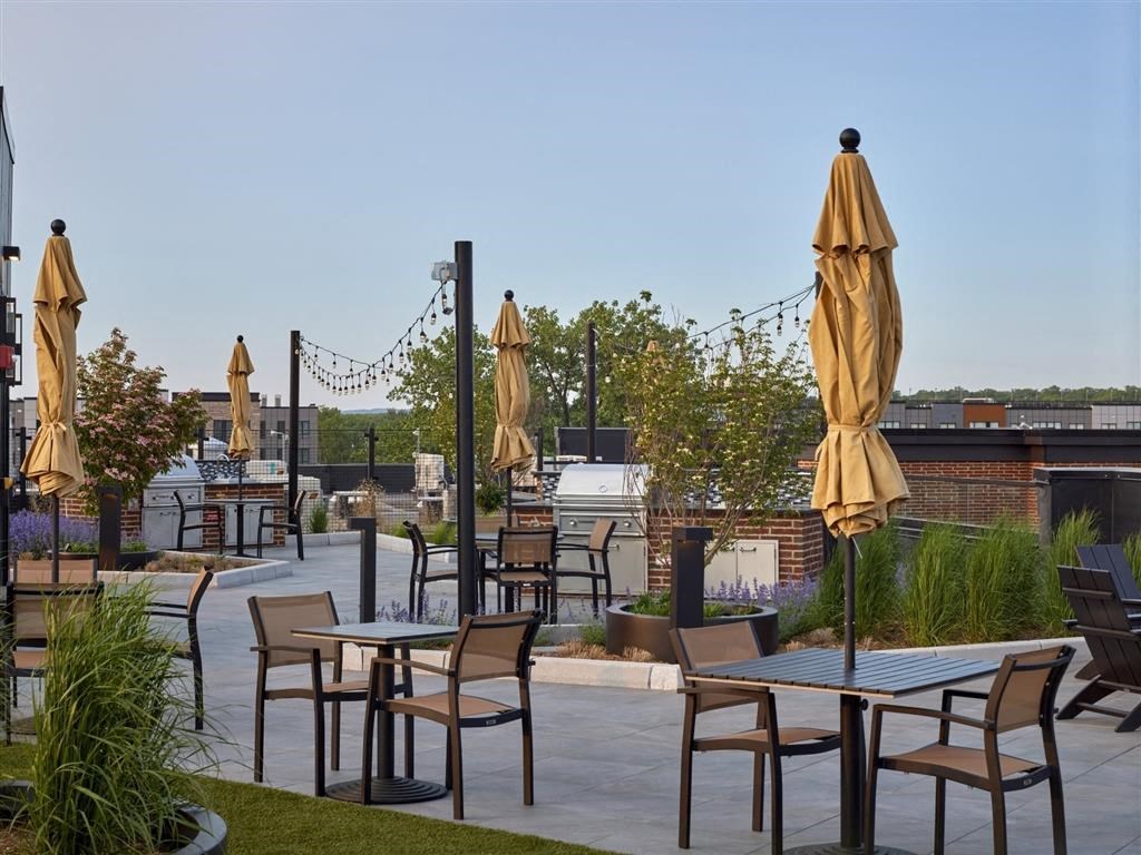 A patio with tables and chairs and umbrellas.