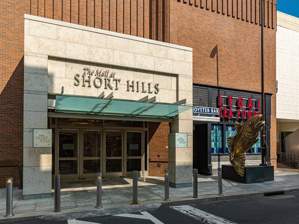 the front of the short hills building with a statue of a fish