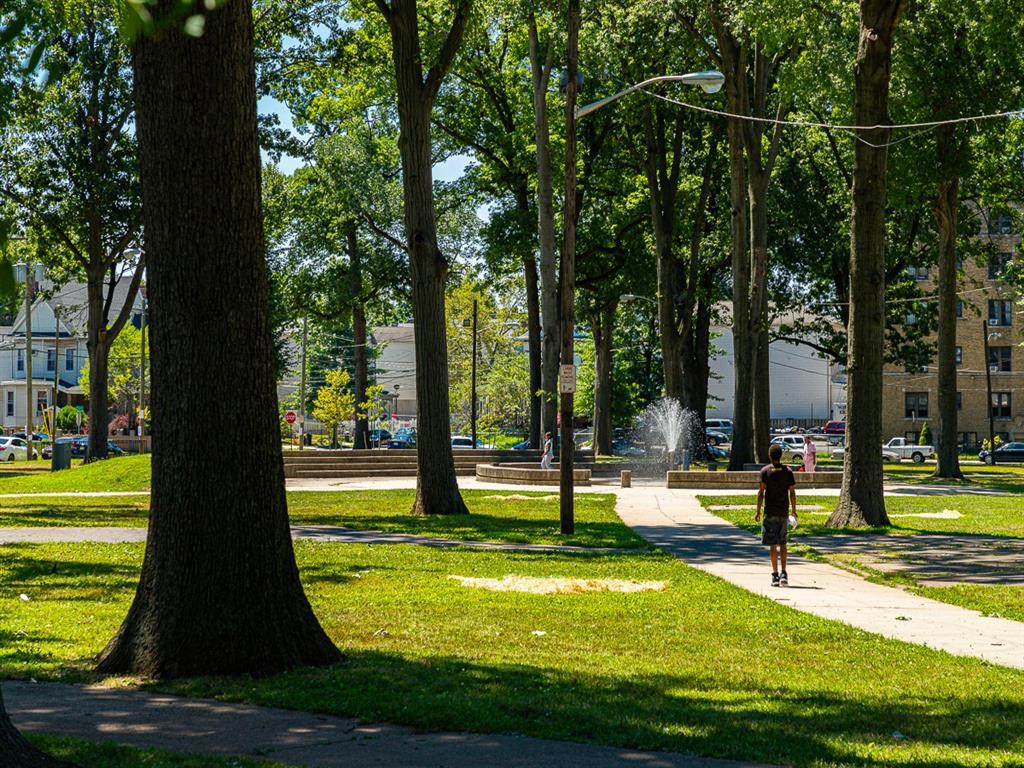 a person walking on a sidewalk in a park