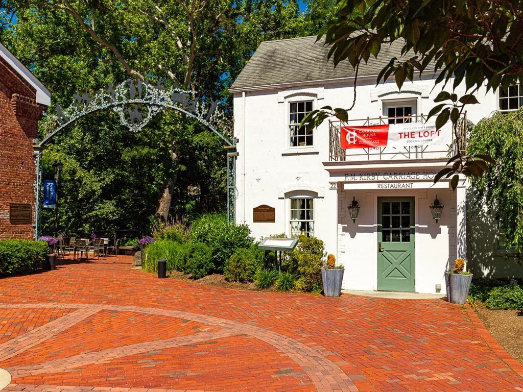 a white building with a green door and a red and white sign