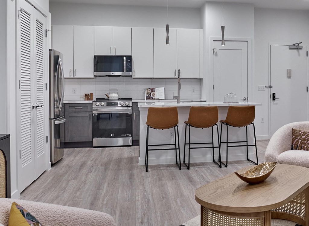 Modern kitchen with stainless steel appliances and bar seating at Ora luxury apartments in Hackensack, NJ