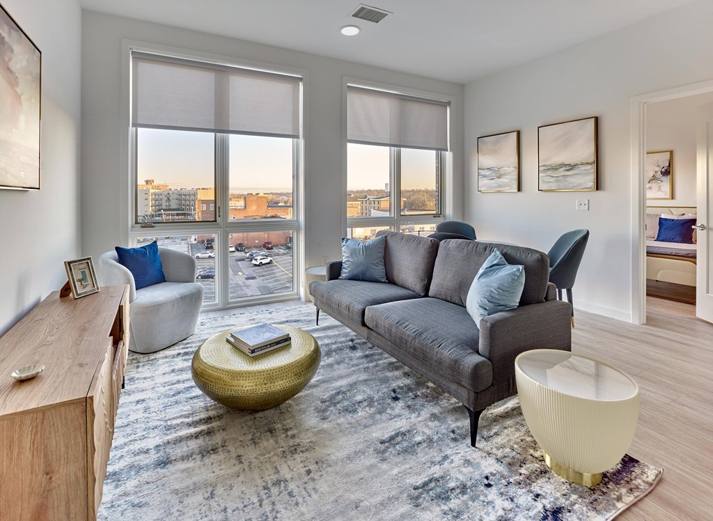 Modern living room with large windows, natural light, and contemporary furnishings at Ora in Hackensack, NJ