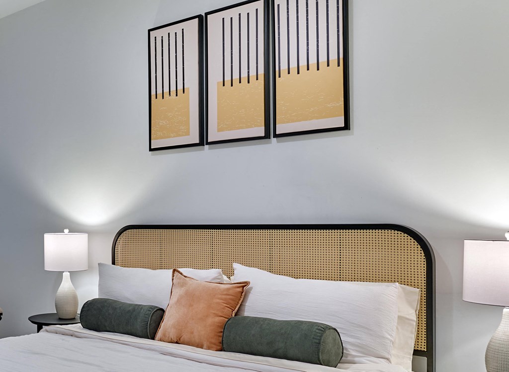 Modern bedroom with bold accent art and cozy furnishings at Ora luxury apartments in Hackensack, NJ