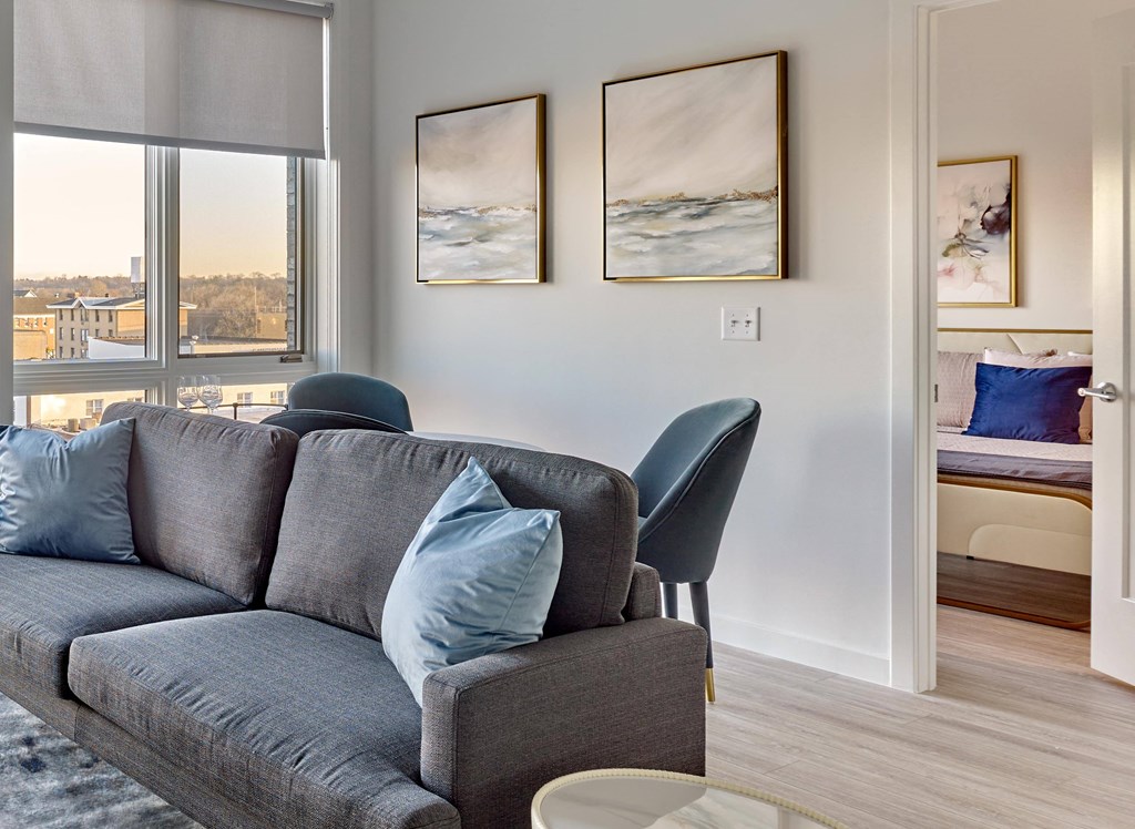 Bright living area with cozy furnishings and large windows at Ora luxury apartments in Hackensack, NJ