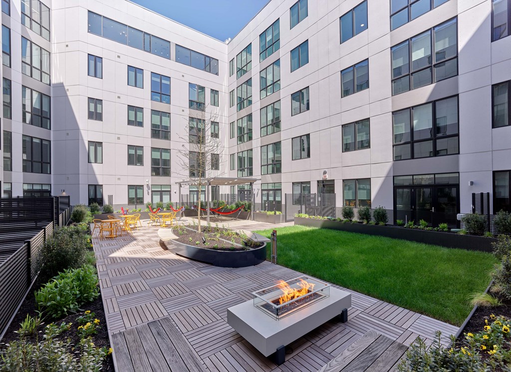 A modern building with a courtyard and a fire pit.