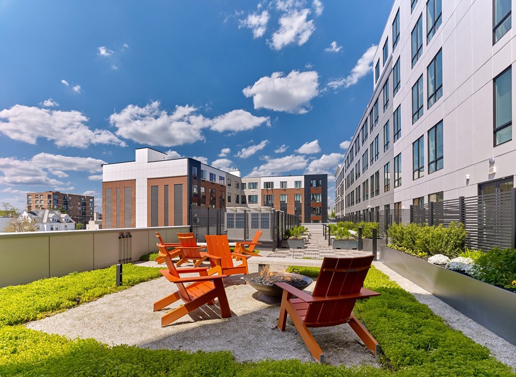 A set of four chairs are arranged on a gravel area in front of a building.