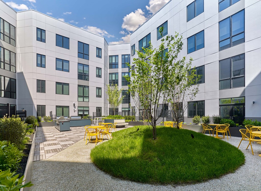 A modern building with a courtyard and yellow chairs.