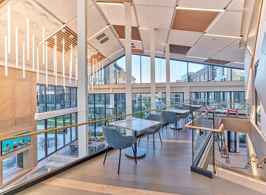 A modern interior with tables and chairs and a balcony.