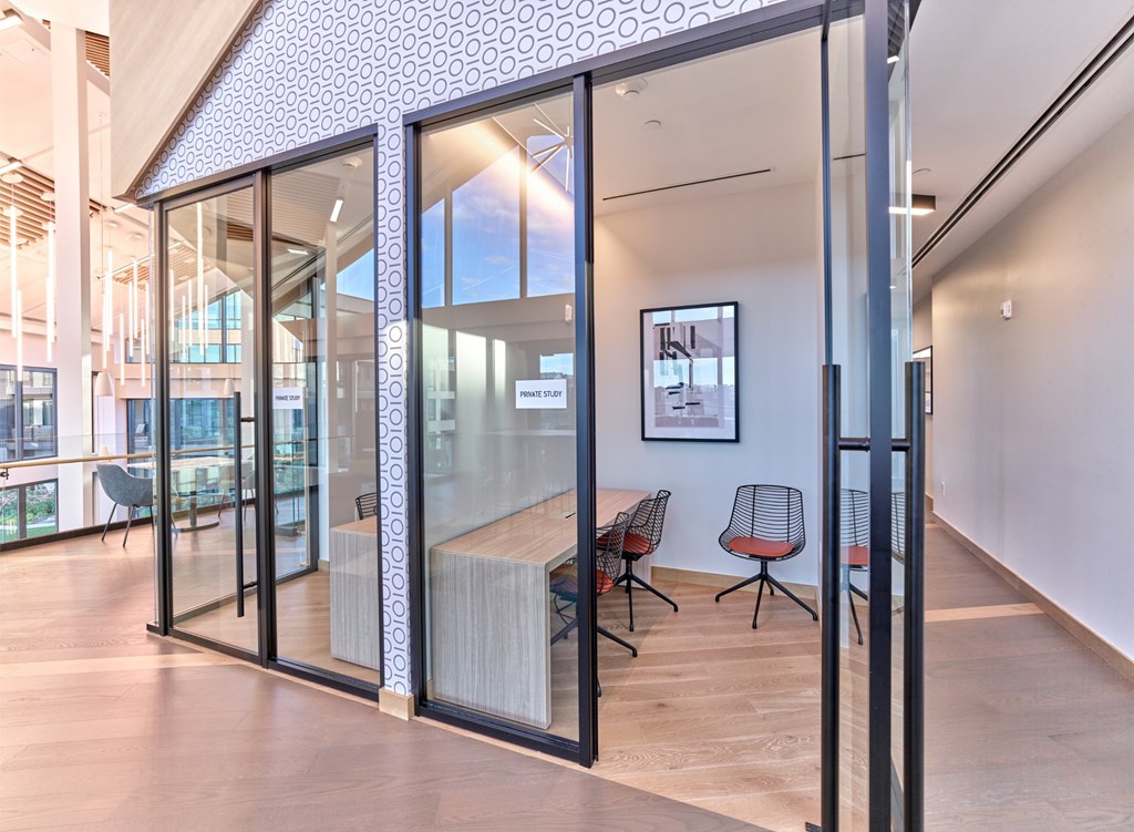 A modern office space with glass walls and wooden floors.