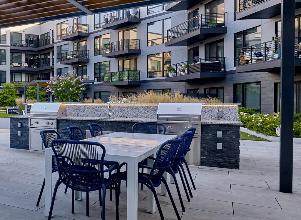 A patio with a table and chairs in front of a building.