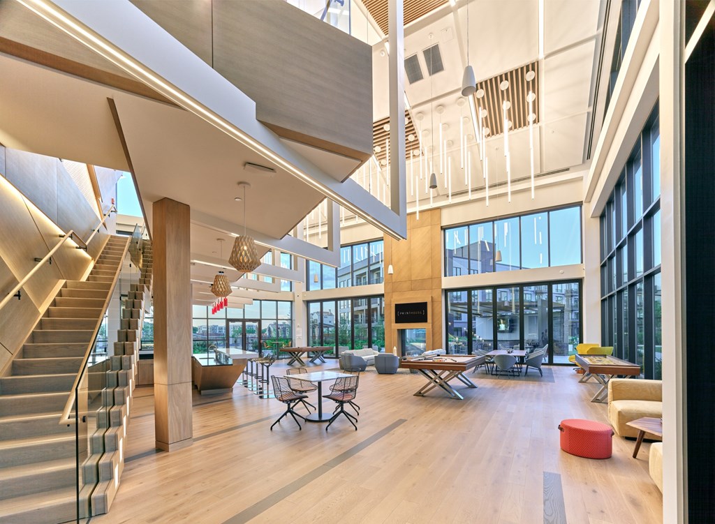 A modern open space with a staircase, tables, and chairs.