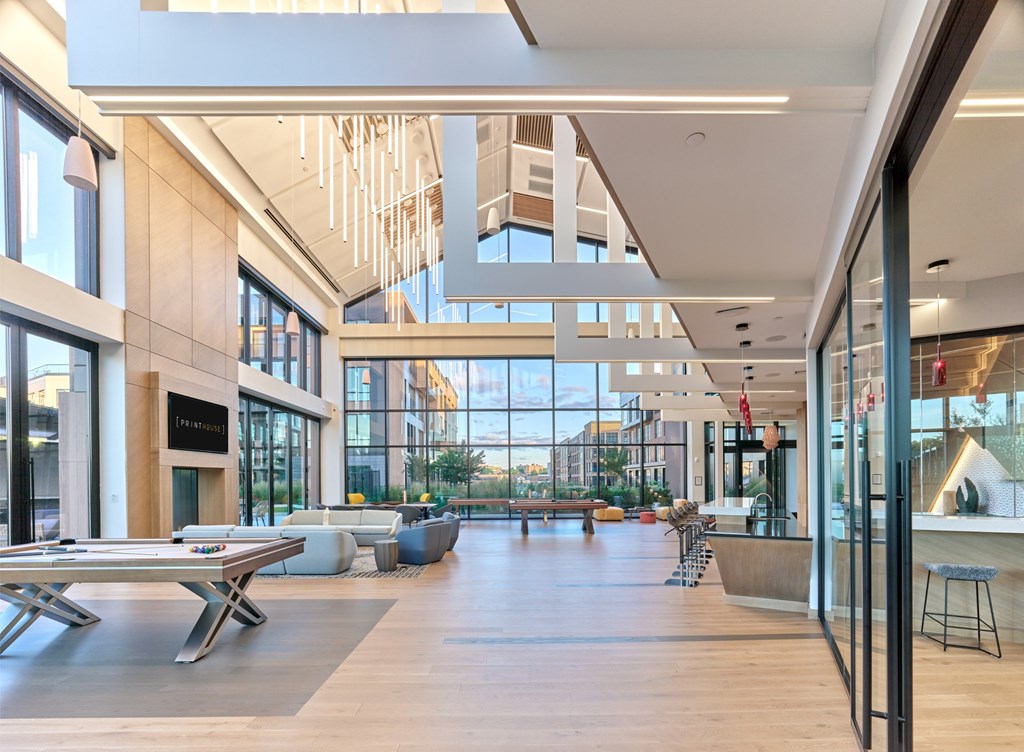 A modern atrium with a glass ceiling and wooden floors.