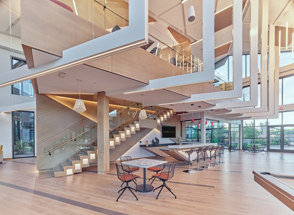 A modern interior with a staircase and a long table.