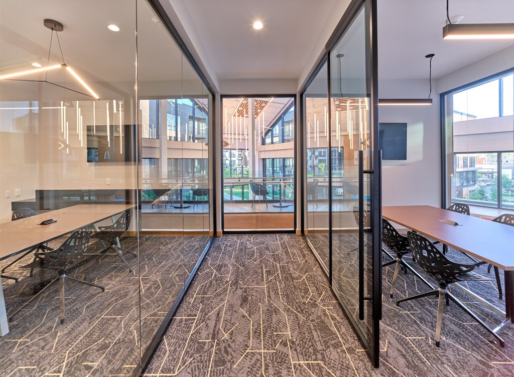 A conference room with glass walls and a carpeted floor.