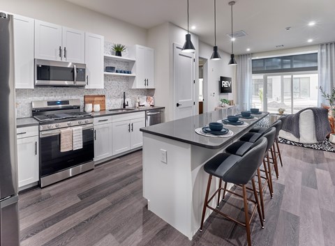 A modern kitchen with white cabinets and a large island.