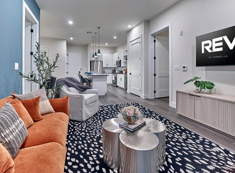 A living room with a sofa, a coffee table, and a plant.