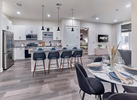 A modern kitchen with a dining table set for four.