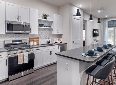A modern kitchen with white cabinets and a black countertop.