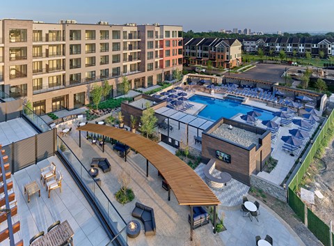 A modern outdoor pool area with a wooden roof and seating area.
